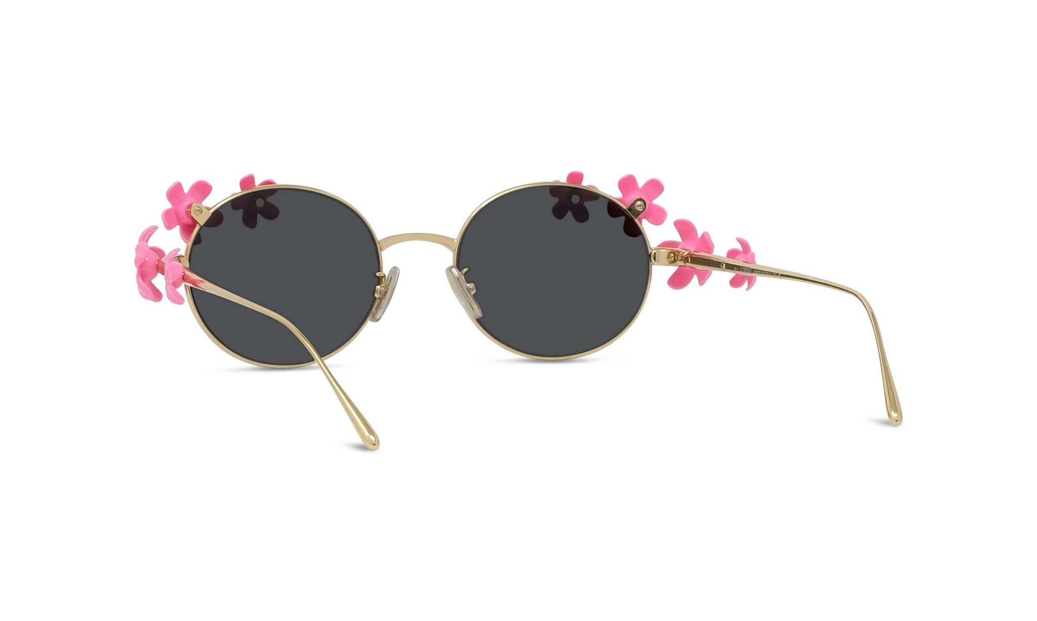 A pair of round sunglasses with black lenses and gold frames adorned with pink flowers.