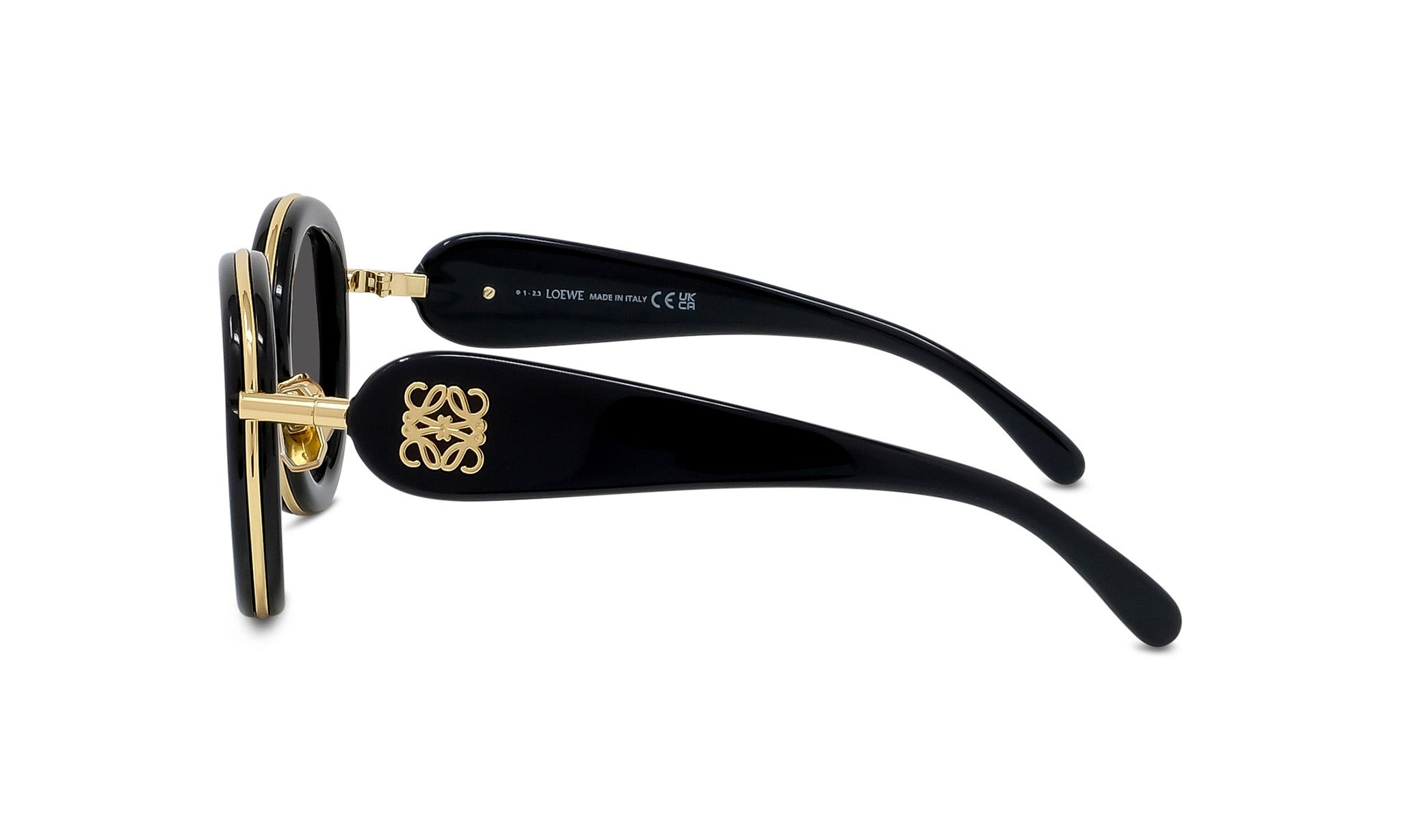 A pair of black sunglasses with gold accents, featuring a distinctive logo on the frame.