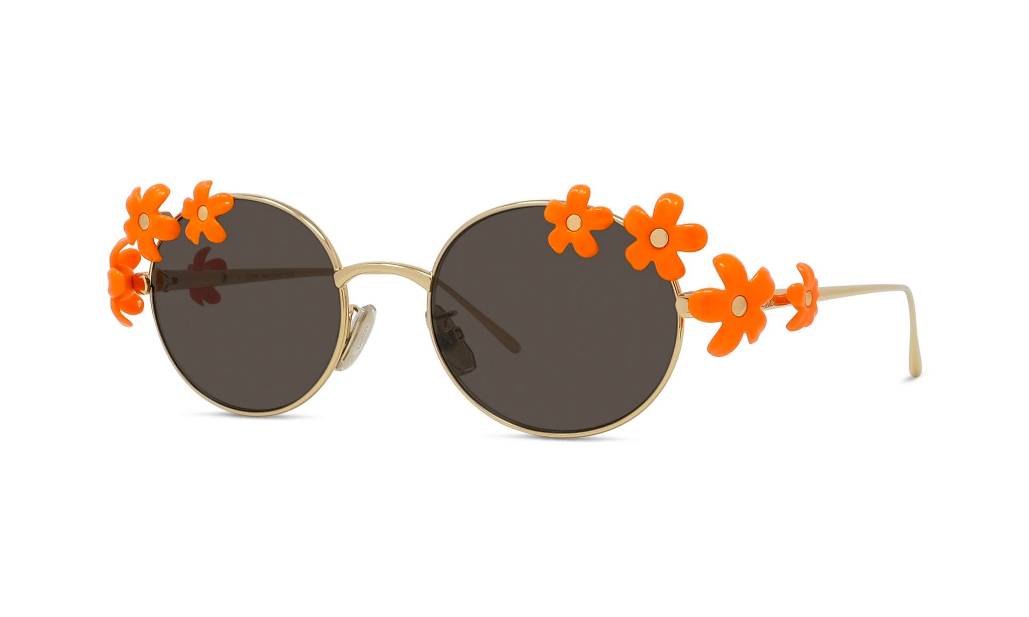 A pair of round sunglasses with dark lenses and orange flower embellishments on the temples.