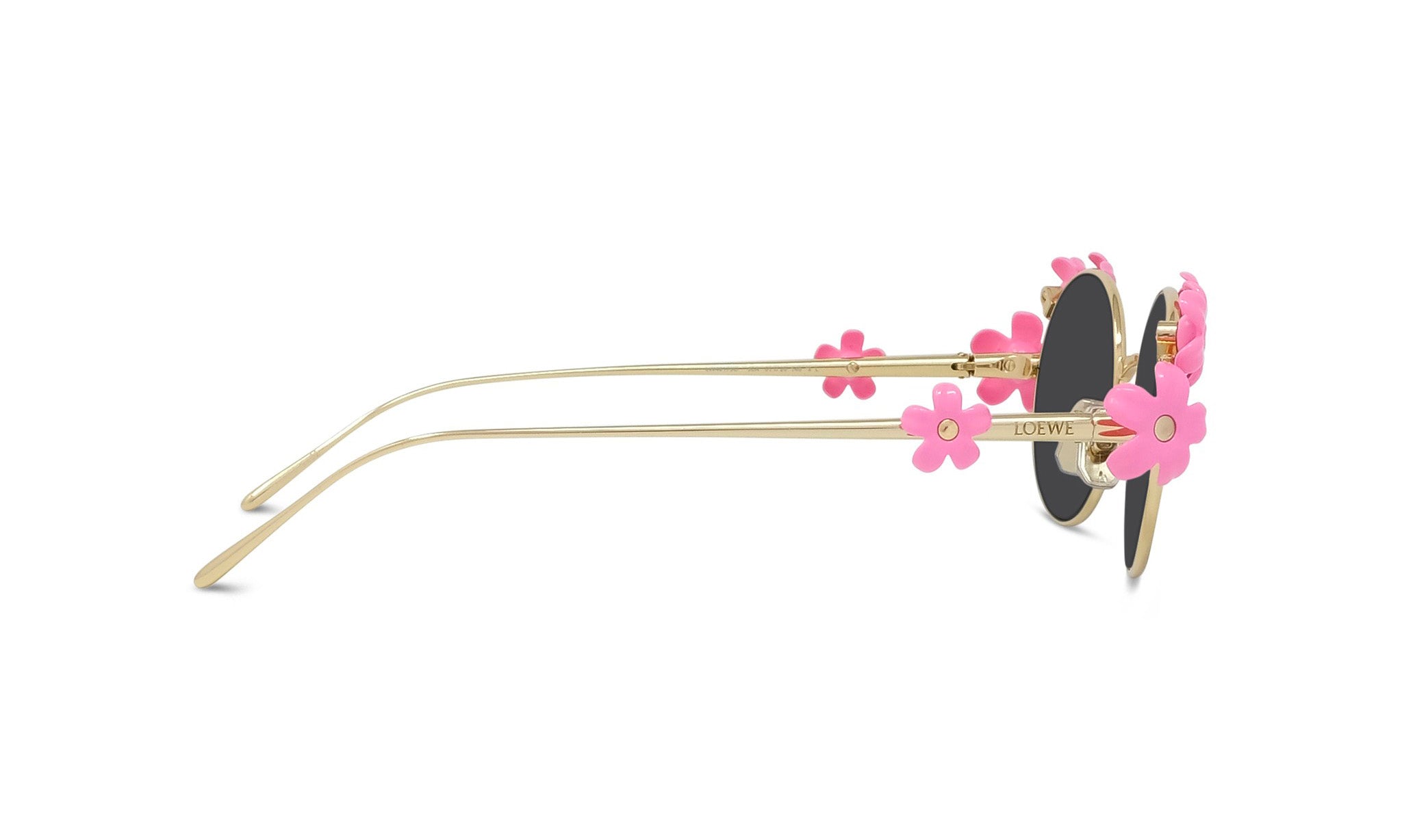 A pair of gold-colored sunglasses with pink flower-shaped embellishments on the temples and arms.
