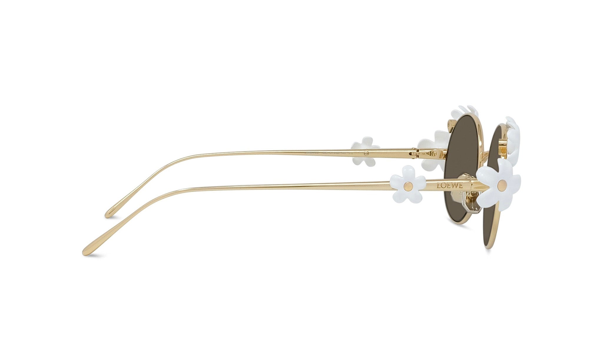 A pair of gold-colored sunglasses with white flower-shaped embellishments on the temples.