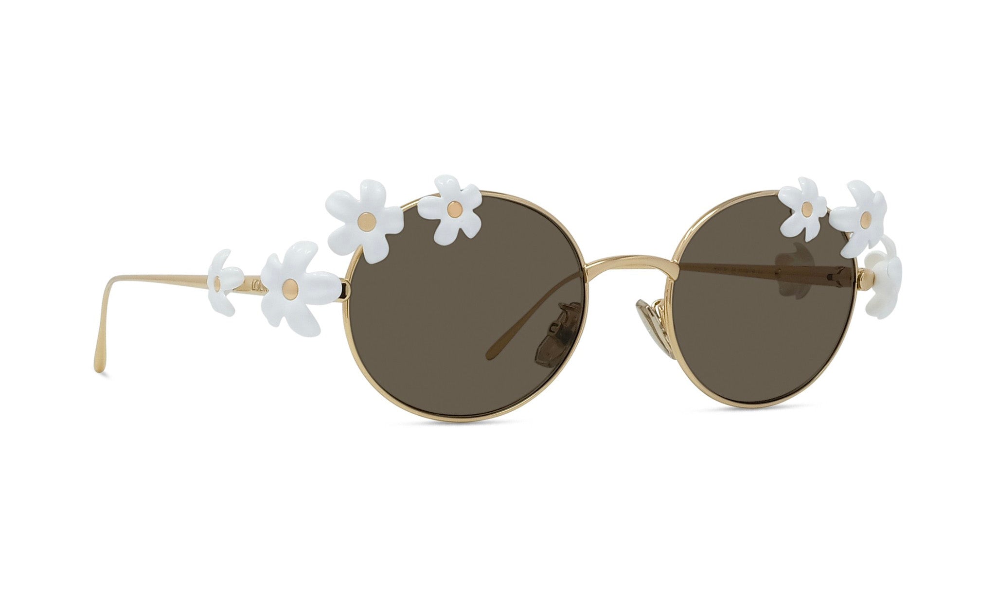 A pair of round sunglasses with a gold frame and dark lenses, adorned with white flower embellishments on the temples.