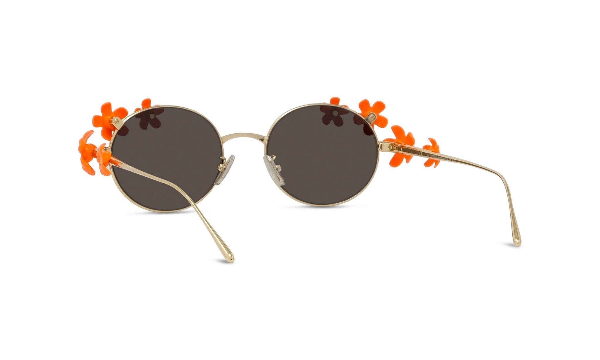 A pair of round sunglasses with dark lenses and orange flower embellishments on the sides.