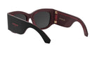 A pair of dark-colored sunglasses with a red accent, featuring the brand name "Christian Dior" on the frame.