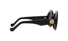 A pair of black sunglasses with gold accents, featuring a round frame and dark lenses.