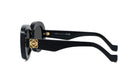 A pair of black sunglasses with gold accents, featuring a round frame and dark lenses.