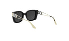 A pair of black sunglasses with gold accents, featuring a Dior logo on the temples.