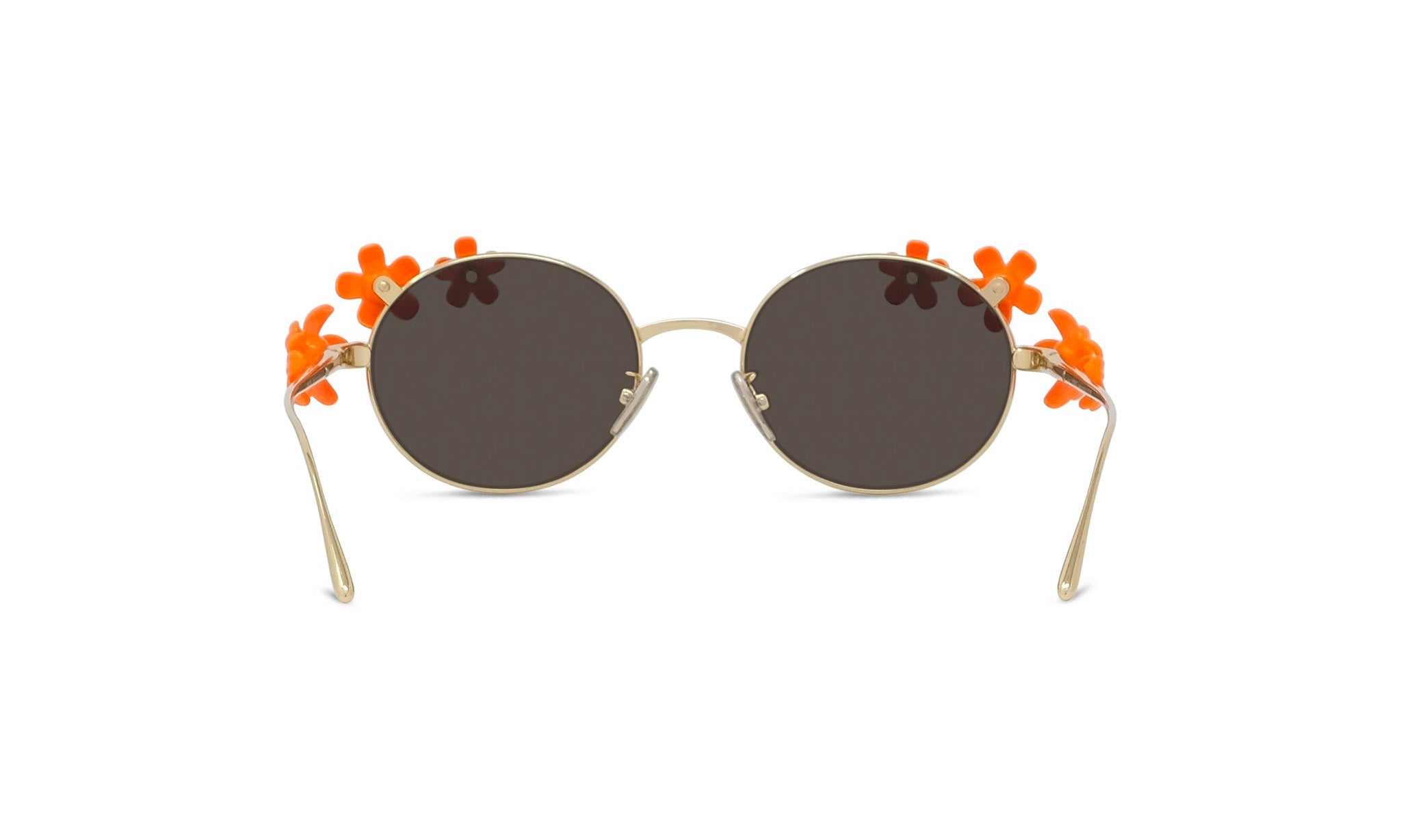 A pair of round sunglasses with dark lenses and gold frames adorned with orange flower decorations.