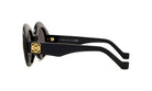 A pair of black sunglasses with gold accents and a logo on the frame.