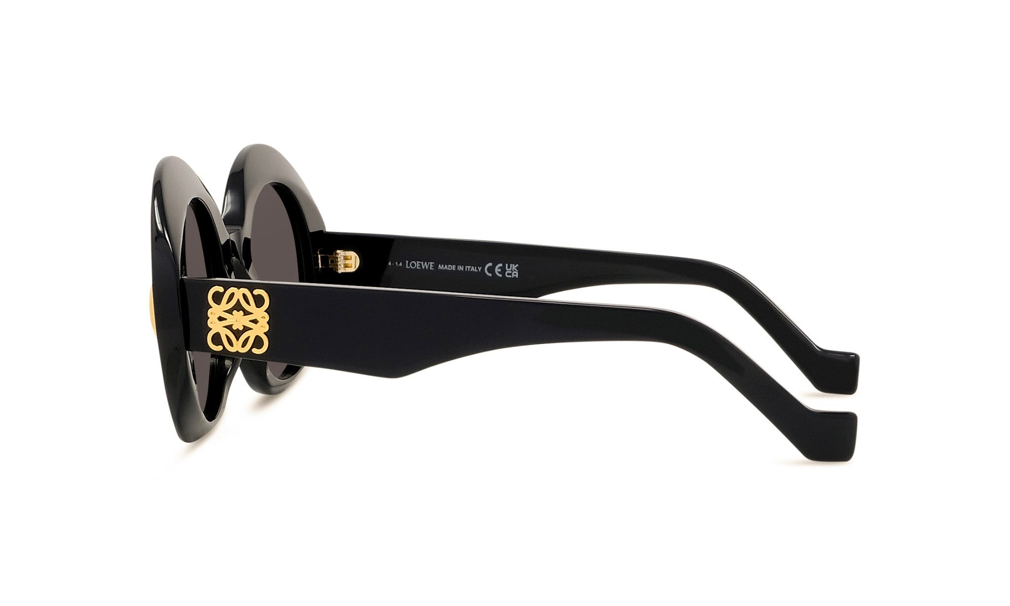 A pair of black sunglasses with gold accents and a logo on the frame.