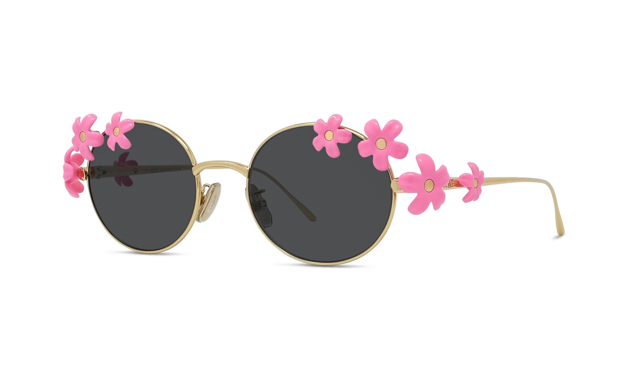 A pair of round sunglasses with a gold frame and dark lenses, adorned with pink flower embellishments on the temples and the sides.