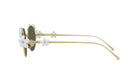 A pair of gold-colored sunglasses with white flower-shaped embellishments on the temples and arms.