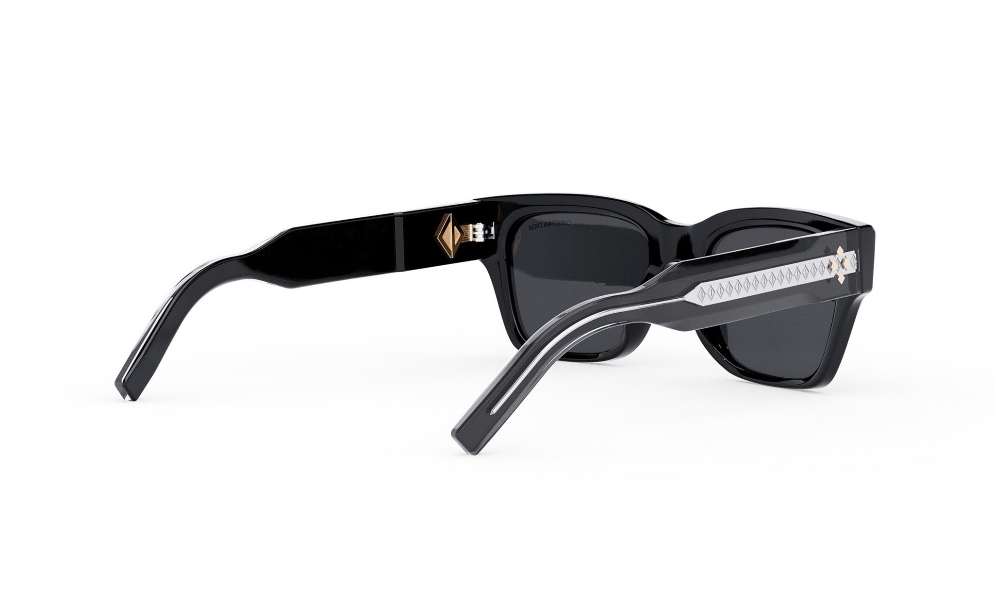 A pair of black sunglasses with a gold-colored logo on the frame.