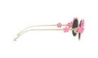 A pair of gold-colored sunglasses with pink flower-shaped embellishments on the temples and arms.