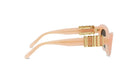 A pair of peach-colored sunglasses with gold-colored metal accents.