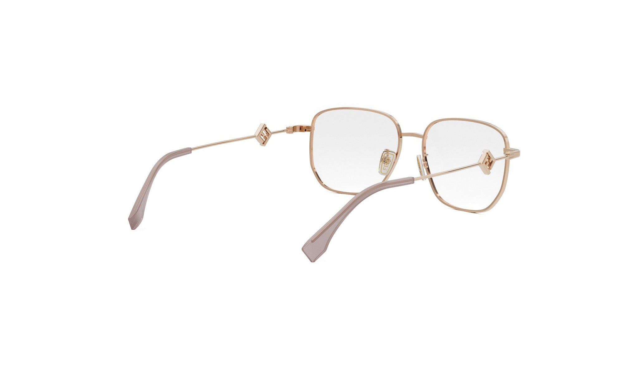 A pair of gold-colored metal-framed glasses with clear lenses, positioned diagonally against a white background.