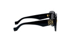 A pair of black sunglasses with gold accents, featuring a distinctive logo on the frame.