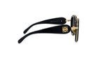 A pair of black sunglasses with gold accents, featuring a distinctive logo on the frame.