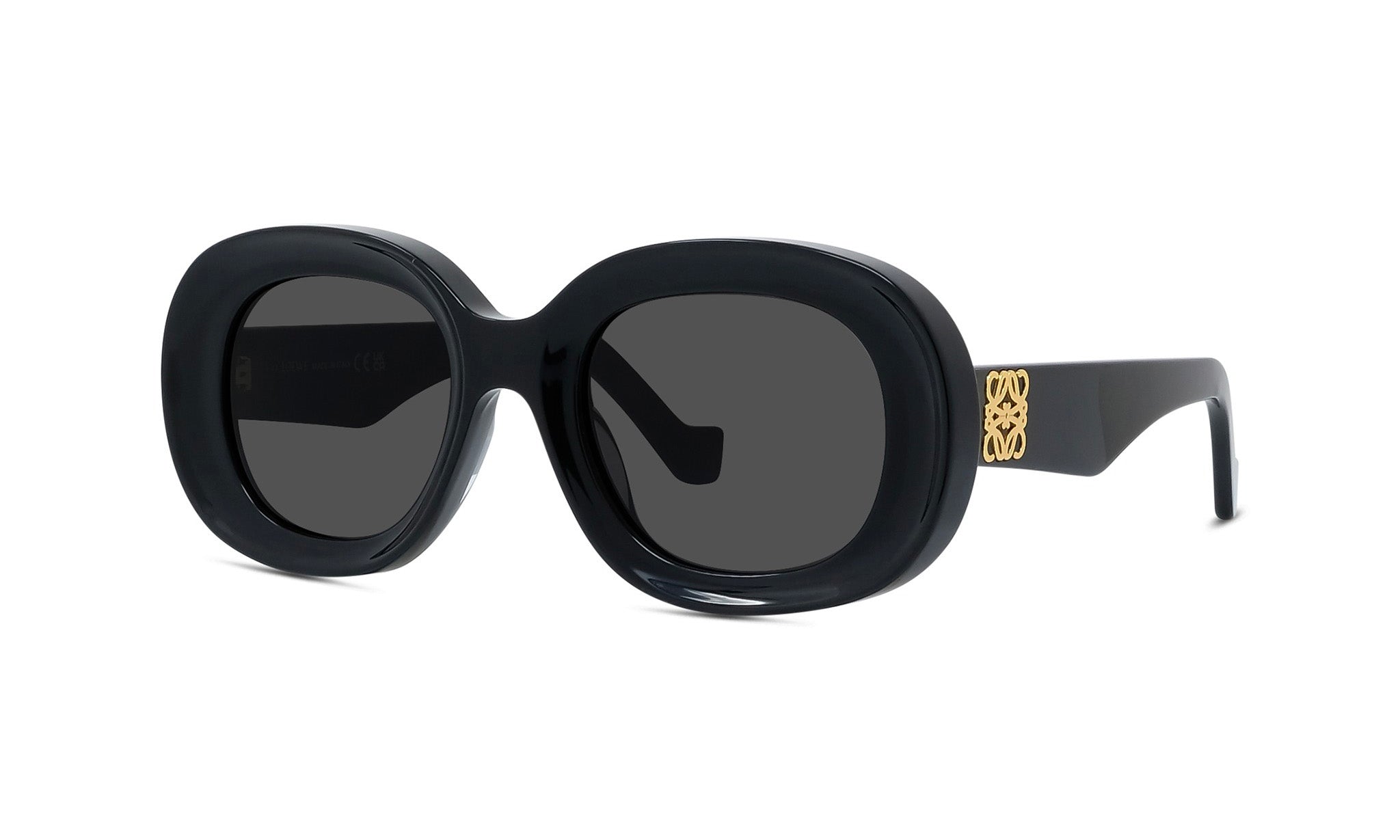 A pair of black sunglasses with a gold logo on the frame.