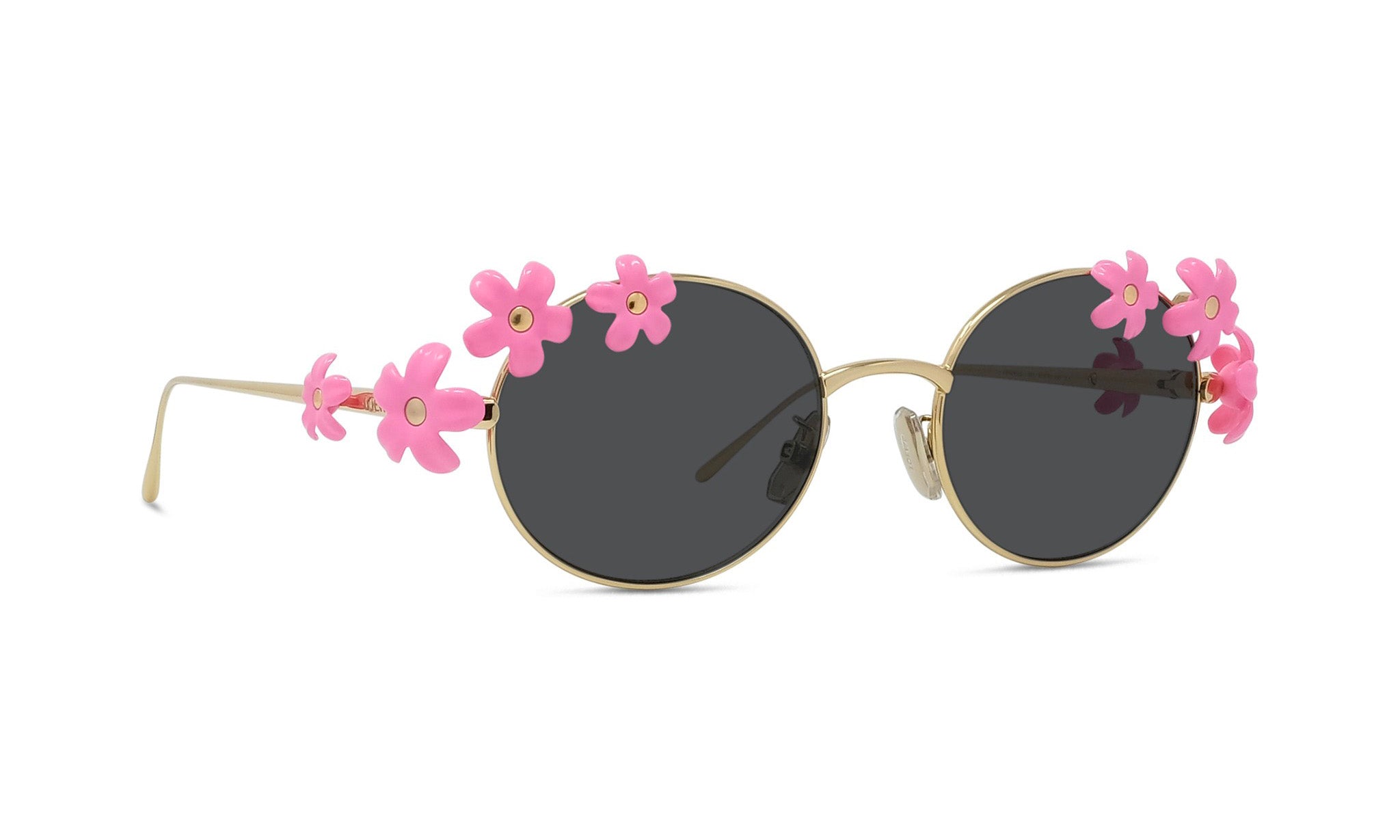A pair of round sunglasses with black lenses and pink flower embellishments on the sides.