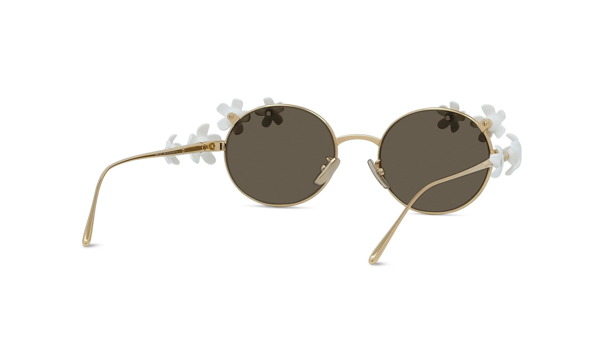 A pair of round, gold-colored sunglasses with dark lenses and white flower-shaped embellishments on the temples.