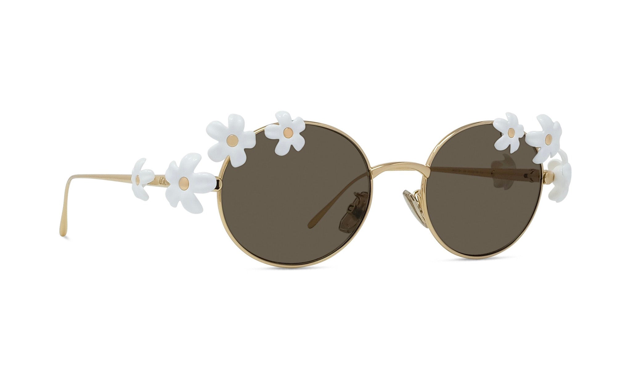 A pair of round sunglasses with a gold frame and dark lenses, adorned with white flower embellishments on the temples.