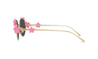 A pair of gold-colored sunglasses with pink flower-shaped embellishments on the temples and arms.