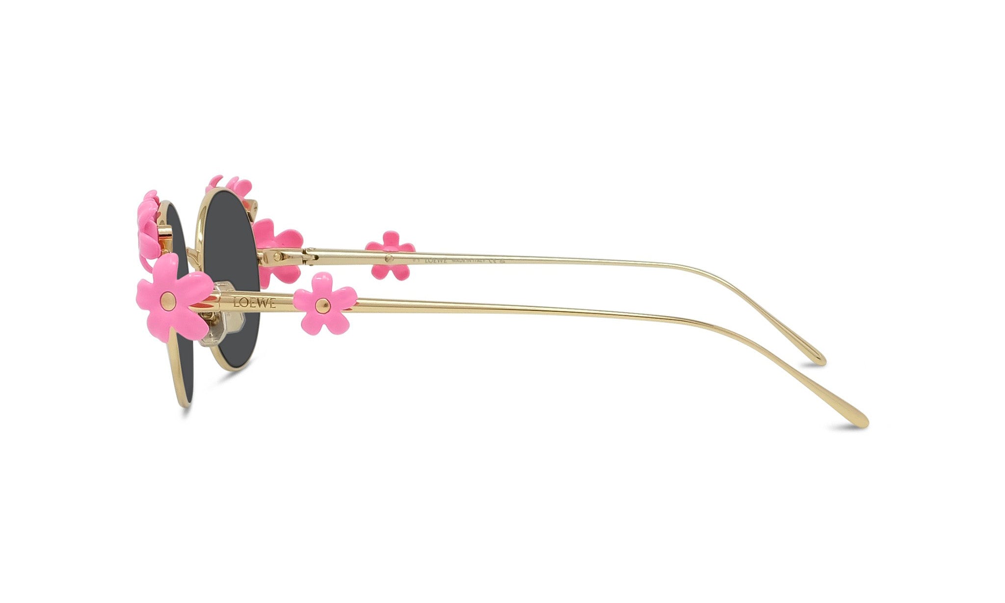 A pair of gold-colored sunglasses with pink flower-shaped embellishments on the temples and arms.